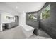 Contemporary bathroom with a soaking tub, tiled shower, vanity, and ample natural light from the window at 7234 Letitia Ln, Sarasota, FL 34241