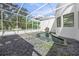 Relaxing courtyard with a pond, stone features, rock ground cover, and screened ceiling at 7234 Letitia Ln, Sarasota, FL 34241