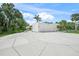 Modern home with a spacious driveway and three-car garage nestled within mature trees at 7234 Letitia Ln, Sarasota, FL 34241