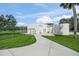 Modern home featuring a white exterior, well-manicured lawn, and paved walkway at 7234 Letitia Ln, Sarasota, FL 34241