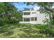 Modern home with a white facade, curved architectural elements, and lush landscaping at 7234 Letitia Ln, Sarasota, FL 34241