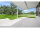 Covered patio overlooking a vast green lawn with mature trees in the background at 7234 Letitia Ln, Sarasota, FL 34241