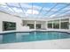 Stunning indoor pool area with a glass ceiling, white tile, and outdoor access at 7234 Letitia Ln, Sarasota, FL 34241