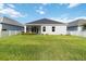 A well-manicured backyard with green grass, a white fence, and an exterior view of the rear of the home at 7526 Ridgelake Cir, Bradenton, FL 34203