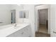 Bright bathroom showcasing a white vanity with double mirrors and access to another bathroom and laundry area at 7526 Ridgelake Cir, Bradenton, FL 34203