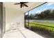 A covered lanai with a ceiling fan, chairs, and a screened view of the landscaped backyard at 7526 Ridgelake Cir, Bradenton, FL 34203