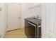 Well-lit laundry room featuring a gray washer and dryer, with a wire rack and door access at 7526 Ridgelake Cir, Bradenton, FL 34203
