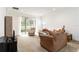 Bright living room featuring neutral carpeting, ample seating, and sliding glass doors to the outside at 7526 Ridgelake Cir, Bradenton, FL 34203
