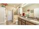 Bright bathroom featuring a tiled shower, cabinetry, granite countertops, framed mirror, and neutral walls at 8352 Enclave Way # 104, Sarasota, FL 34243