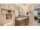 Bathroom with double sinks, granite countertops, cabinetry, framed mirrors, and neutral walls at 8352 Enclave Way # 104, Sarasota, FL 34243