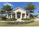 Community clubhouse featuring lush landscaping, palm trees, and covered entrance at 8352 Enclave Way # 104, Sarasota, FL 34243