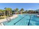Resort-style community pool featuring lap lanes, poolside seating, and mature landscaping at 8352 Enclave Way # 104, Sarasota, FL 34243