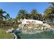 Community entrance sign with water feature, palm trees, and well-maintained landscaping at 8352 Enclave Way # 104, Sarasota, FL 34243