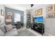Comfortable living room with a sofa, desk, shelving, decorations, and a wall-mounted television at 8352 Enclave Way # 104, Sarasota, FL 34243