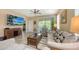 Comfortable living room featuring neutral walls, ceiling fan, and sliding glass doors to the outdoor patio at 8352 Enclave Way # 104, Sarasota, FL 34243