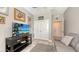 Comfortable living room with a sofa, shelving, neutral walls, decor, and a wall-mounted television at 8352 Enclave Way # 104, Sarasota, FL 34243
