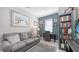 Cozy living room with a sofa, desk, shelving, decor, wall art, and a window at 8352 Enclave Way # 104, Sarasota, FL 34243