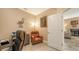 A well-lit home office featuring neutral colored walls, an accent chair, and a view into the living room at 8352 Enclave Way # 104, Sarasota, FL 34243