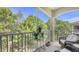 A screened-in patio with a view of the surrounding trees, and wicker chairs at 8352 Enclave Way # 104, Sarasota, FL 34243