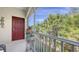 A screened-in patio featuring a red front door, a plant stand, and a beautiful view of the surrounding trees at 8352 Enclave Way # 104, Sarasota, FL 34243