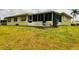 Back exterior showcasing its spacious yard, screened-in patio, and neutral paint at 8508 43Rd W Ave, Bradenton, FL 34209