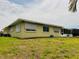Back exterior showcasing its spacious yard, screened-in patio, and neutral paint at 8508 43Rd W Ave, Bradenton, FL 34209