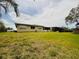 Back exterior showcasing its spacious yard, screened-in patio, and neutral paint at 8508 43Rd W Ave, Bradenton, FL 34209