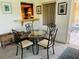 Bright dining area with glass table and wrought iron chairs, next to a kitchen pass-through at 8508 43Rd W Ave, Bradenton, FL 34209