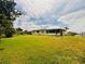 Lush, expansive yard leading to a home featuring a screened-in patio, providing ample space for outdoor enjoyment at 8508 43Rd W Ave, Bradenton, FL 34209