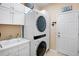 Efficient laundry room with modern washer and dryer, ample cabinet storage, and a convenient sink area at 9052 41St E St, Parrish, FL 34219