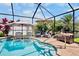 Enclosed pool with sun umbrellas, various seating options, and a lush green landscape at 9052 41St E St, Parrish, FL 34219