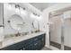 Bathroom with dual sinks, quartz countertops, framed mirrors, and a glass-enclosed shower at 9560 High Gate Dr # 1622, Sarasota, FL 34238