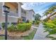 Beautiful condo exterior with lush landscaping, screened in porch, and walkway on a sunny day at 9560 High Gate Dr # 1622, Sarasota, FL 34238