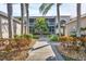 Condo exterior view featuring palm trees, well-maintained landscaping, and screened in porch at 9560 High Gate Dr # 1622, Sarasota, FL 34238