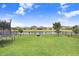 Spacious backyard with trampoline, fire pit, manicured lawn, and view of the community lake at 9646 Ivory Dr, Ruskin, FL 33573