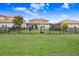 Grassy backyard with black metal fence, plants, and trampoline at 9646 Ivory Dr, Ruskin, FL 33573