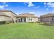 Spacious backyard with manicured lawn, covered patio, and well-maintained landscaping at 9646 Ivory Dr, Ruskin, FL 33573