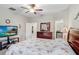 Bright bedroom featuring soft carpet, ceiling fan, and a large window that brightens up the space at 9646 Ivory Dr, Ruskin, FL 33573