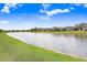 Scenic community lake surrounded by lush green grass and beautiful neighborhood homes on a sunny day at 9646 Ivory Dr, Ruskin, FL 33573