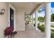 Covered porch with brick pavers, white columns, and cozy seating area at 9646 Ivory Dr, Ruskin, FL 33573