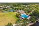 Aerial view of community pool, tennis courts, and clubhouse surrounded by lush landscape at 9840 50Th Street E Cir, Parrish, FL 34219
