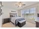 Cozy bedroom featuring a large window, ceiling fan, and neutral decor at 9840 50Th Street E Cir, Parrish, FL 34219