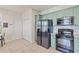 Bright kitchen with modern appliances, sage-green cabinets, tile flooring, and direct access to another room at 9840 50Th Street E Cir, Parrish, FL 34219