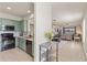 An open-concept kitchen features mint-green cabinetry, modern appliances, and an open view to the dining and living area at 9840 50Th Street E Cir, Parrish, FL 34219