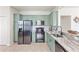 Well-lit kitchen features stainless steel appliances, modern cabinets, marble countertops, and neutral tile flooring at 9840 50Th Street E Cir, Parrish, FL 34219
