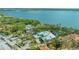 Aerial view of waterfront property with lush landscaping, pool, and waterfront access at 1042 N Casey Key Rd, Osprey, FL 34229