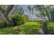 Spacious backyard with green grass and landscaping offering serene water views at 1042 N Casey Key Rd, Osprey, FL 34229