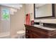 Bathroom featuring a dark wood vanity with black countertop and window providing natural light at 1042 N Casey Key Rd, Osprey, FL 34229