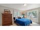 Cozy bedroom features a large dresser, access to a balcony, and a view of the surrounding waterfront at 1042 N Casey Key Rd, Osprey, FL 34229