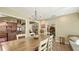 Open dining room with view into kitchen, wood table, chairs, and brick floors at 1042 N Casey Key Rd, Osprey, FL 34229